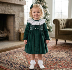 Bambina con abito in velluto verde con collo a balze